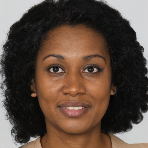 Joyful black young-adult female with long  brown hair and brown eyes