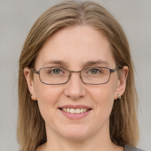 Joyful white adult female with medium  brown hair and blue eyes