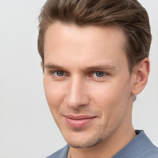 Joyful white young-adult male with short  brown hair and grey eyes