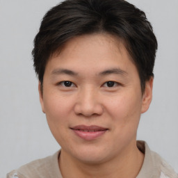 Joyful asian young-adult male with short  brown hair and brown eyes