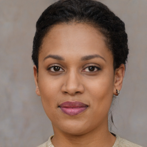 Joyful black young-adult female with short  black hair and brown eyes