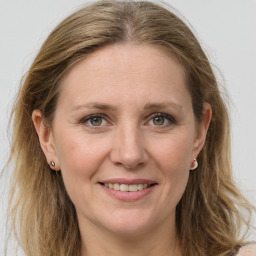 Joyful white adult female with long  brown hair and grey eyes