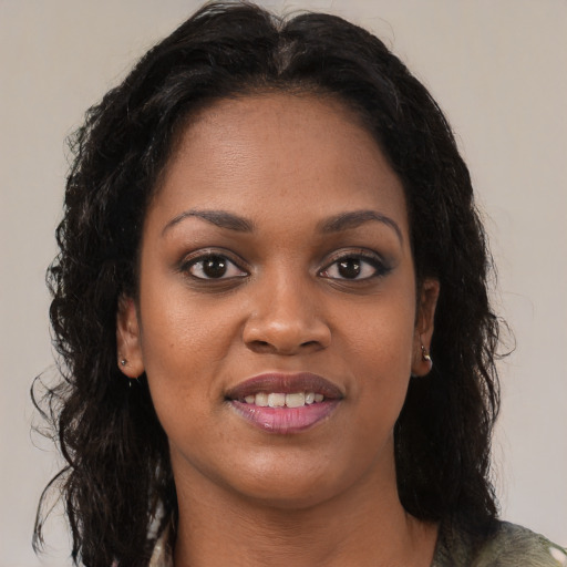 Joyful black young-adult female with long  brown hair and brown eyes
