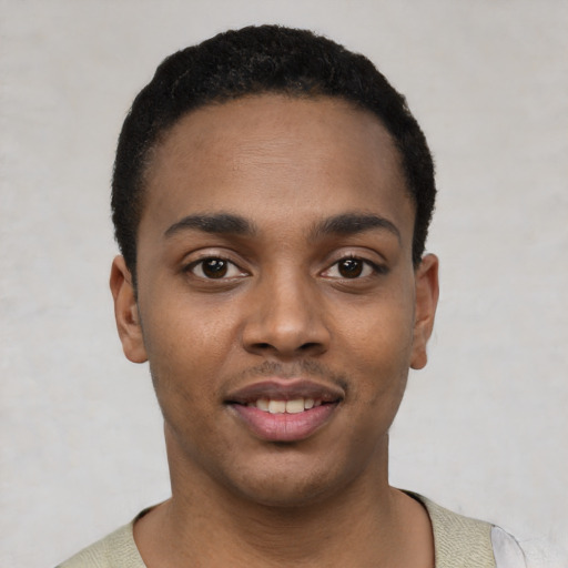 Joyful black young-adult male with short  black hair and brown eyes