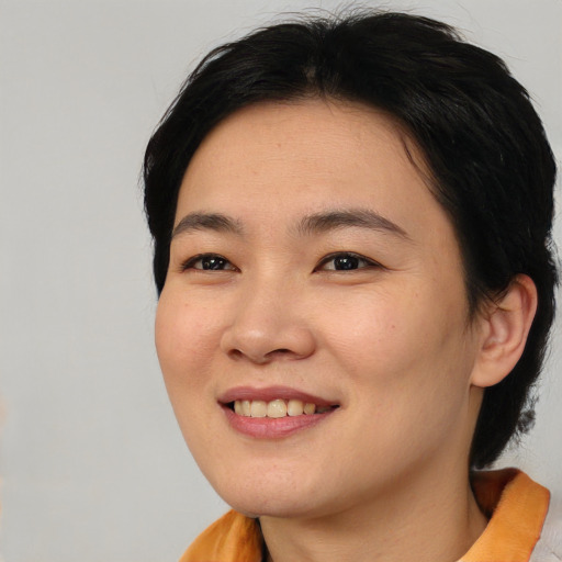 Joyful asian young-adult female with medium  brown hair and brown eyes