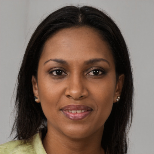 Joyful black young-adult female with long  brown hair and brown eyes