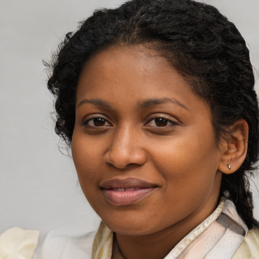 Joyful black young-adult female with long  brown hair and brown eyes