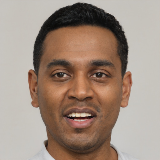 Joyful black young-adult male with short  black hair and brown eyes