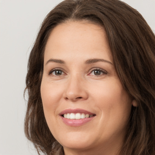 Joyful white young-adult female with long  brown hair and brown eyes