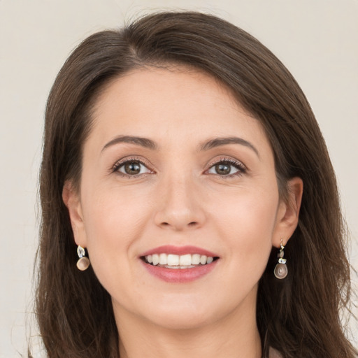 Joyful white young-adult female with long  brown hair and grey eyes