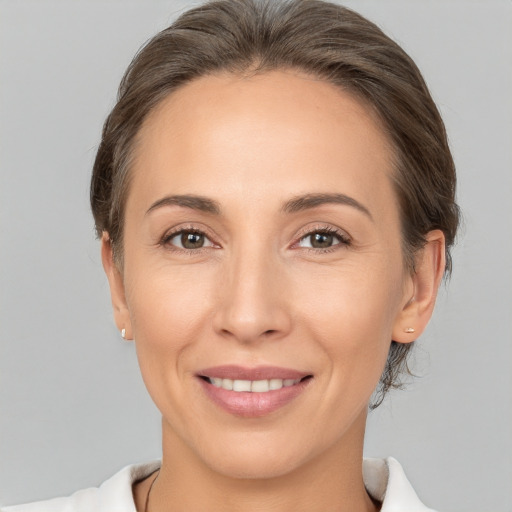 Joyful white adult female with medium  brown hair and brown eyes