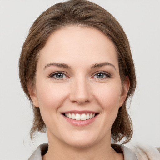 Joyful white young-adult female with medium  brown hair and grey eyes