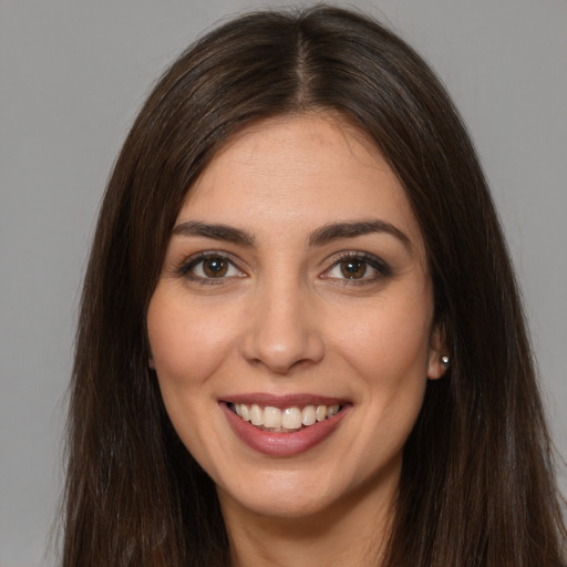 Joyful white young-adult female with long  brown hair and brown eyes