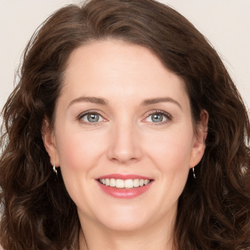 Joyful white young-adult female with long  brown hair and green eyes