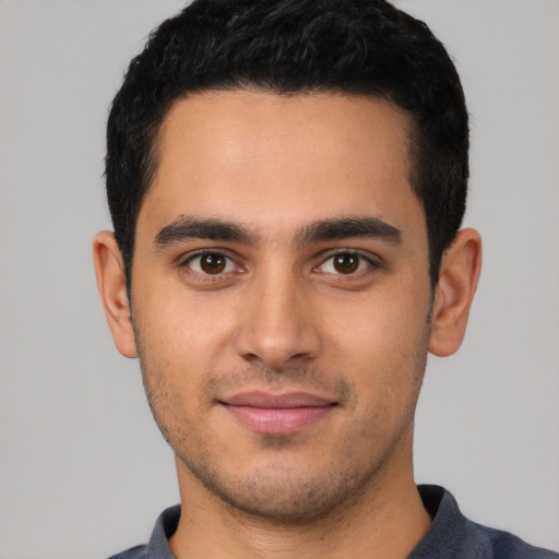 Joyful latino young-adult male with short  black hair and brown eyes