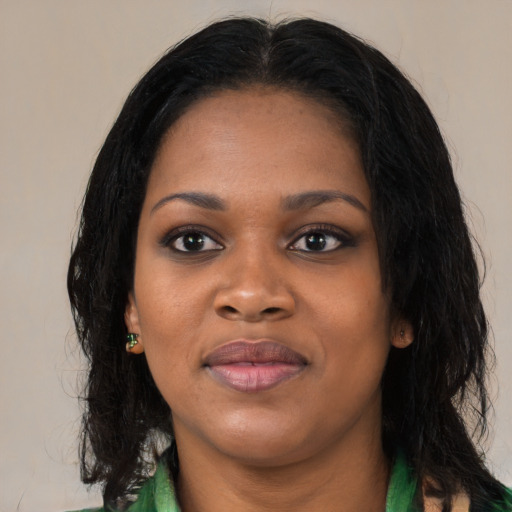 Joyful black young-adult female with long  black hair and brown eyes
