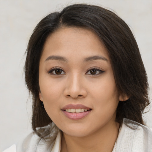 Joyful latino young-adult female with long  brown hair and brown eyes