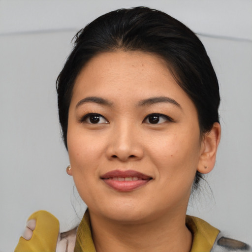 Joyful asian young-adult female with medium  brown hair and brown eyes