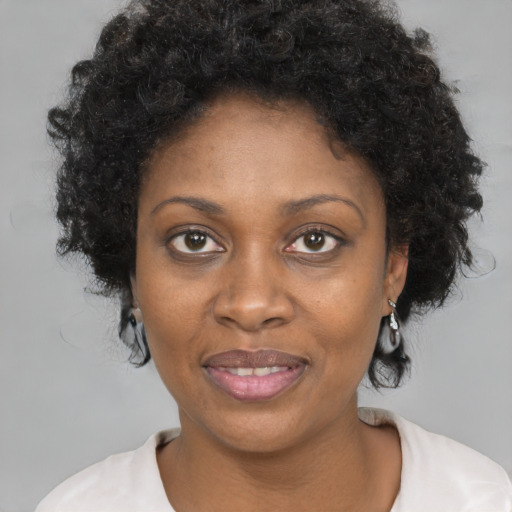 Joyful black adult female with short  brown hair and brown eyes
