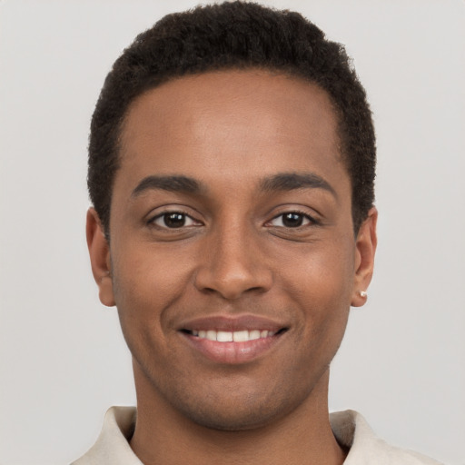 Joyful black young-adult male with short  brown hair and brown eyes