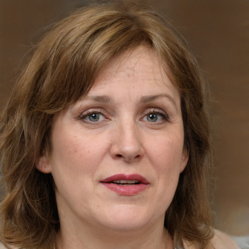 Joyful white adult female with medium  brown hair and grey eyes