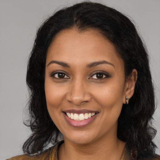 Joyful black young-adult female with long  brown hair and brown eyes