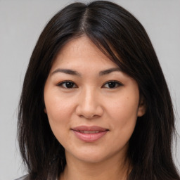 Joyful asian young-adult female with long  brown hair and brown eyes