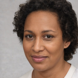 Joyful black adult female with medium  brown hair and brown eyes