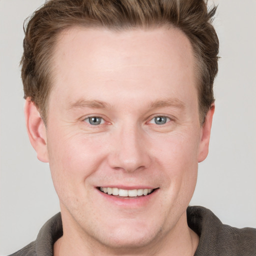 Joyful white adult male with short  brown hair and grey eyes