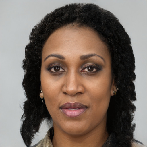 Joyful black adult female with long  black hair and brown eyes