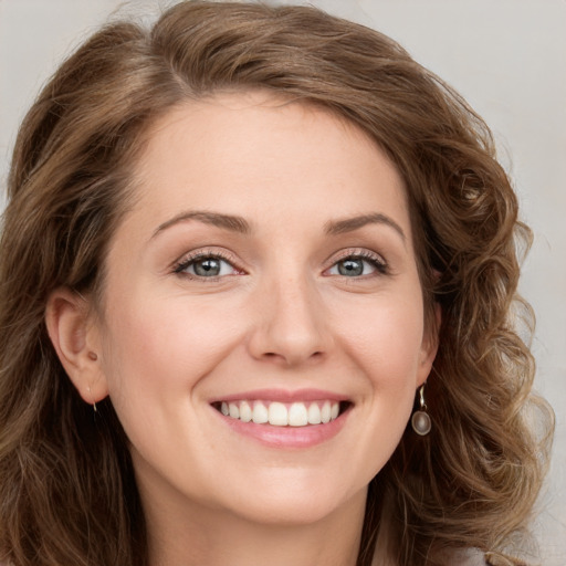 Joyful white young-adult female with long  brown hair and green eyes