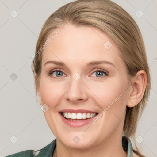 Joyful white young-adult female with medium  brown hair and blue eyes