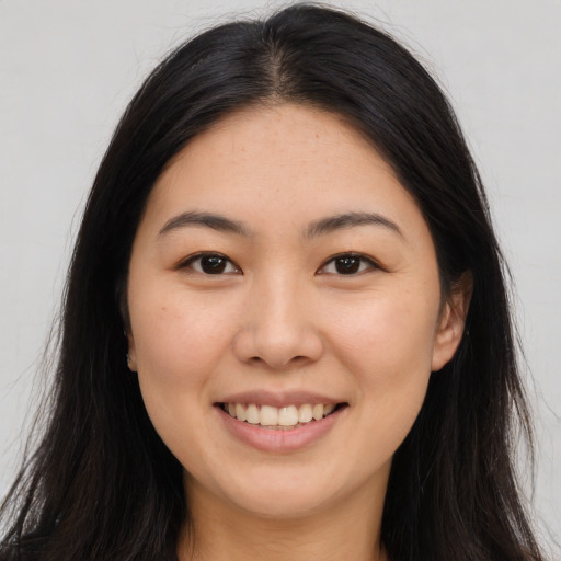 Joyful asian young-adult female with long  brown hair and brown eyes