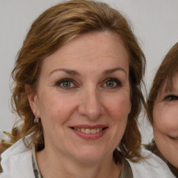 Joyful white adult female with medium  brown hair and blue eyes