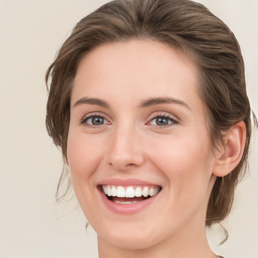 Joyful white young-adult female with medium  brown hair and green eyes