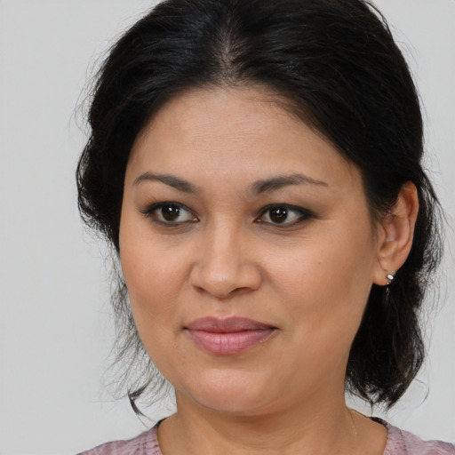 Joyful latino adult female with medium  brown hair and brown eyes