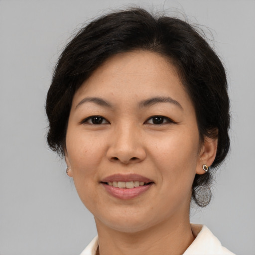 Joyful asian adult female with medium  brown hair and brown eyes
