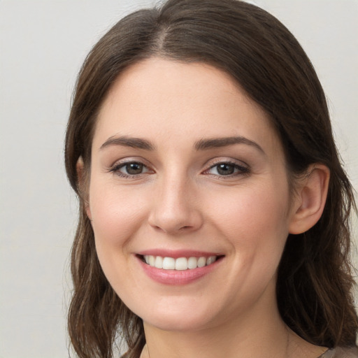 Joyful white young-adult female with long  brown hair and grey eyes