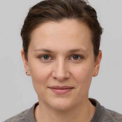 Joyful white young-adult female with short  brown hair and grey eyes