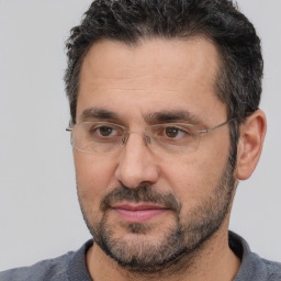 Joyful white adult male with short  black hair and brown eyes