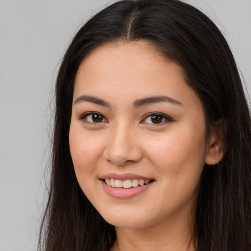 Joyful white young-adult female with long  brown hair and brown eyes