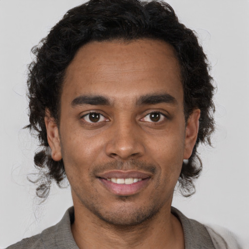 Joyful black young-adult male with short  brown hair and brown eyes