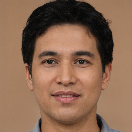 Joyful asian young-adult male with short  brown hair and brown eyes