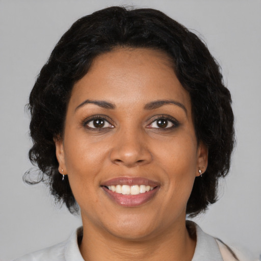 Joyful black young-adult female with medium  brown hair and brown eyes