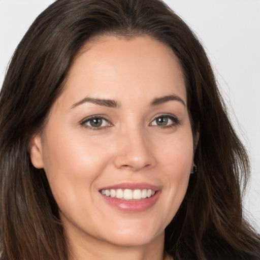 Joyful white young-adult female with long  brown hair and brown eyes