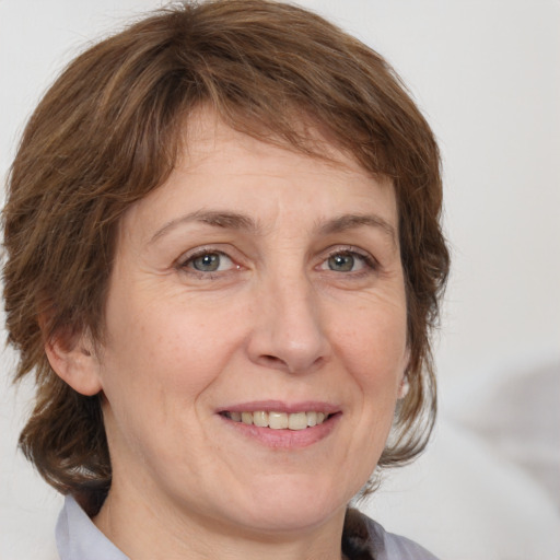 Joyful white adult female with medium  brown hair and grey eyes