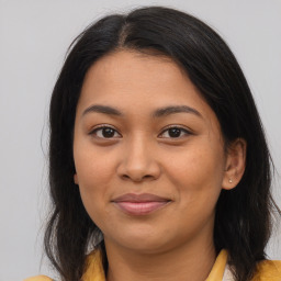 Joyful latino young-adult female with medium  brown hair and brown eyes