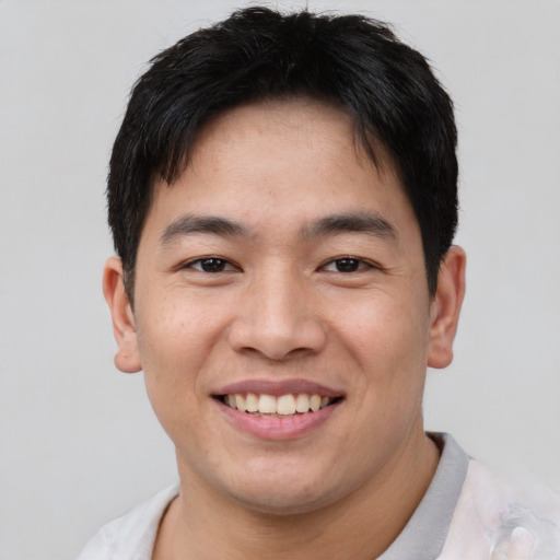 Joyful asian young-adult male with short  brown hair and brown eyes