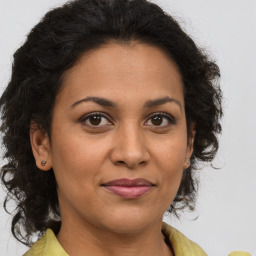 Joyful latino adult female with medium  brown hair and brown eyes