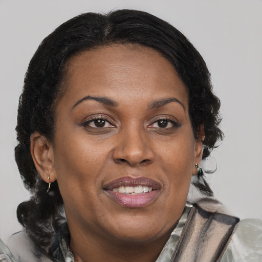 Joyful black adult female with medium  brown hair and brown eyes